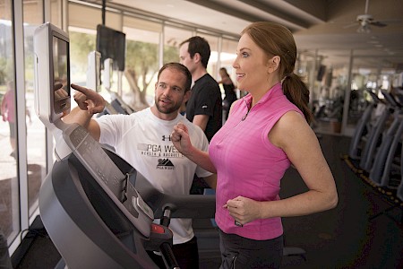 Personal trainer working with client in gym